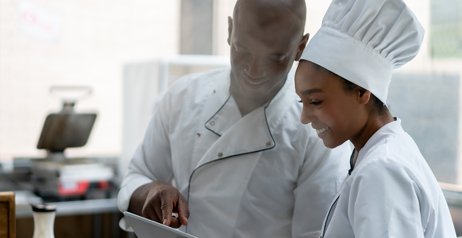 Two Chefs discuss while using tablet computer