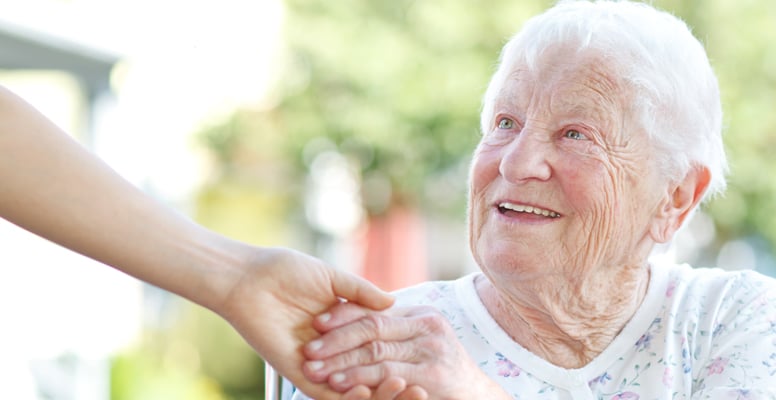 Happy patient is holding caregiver for a hand while spending time together