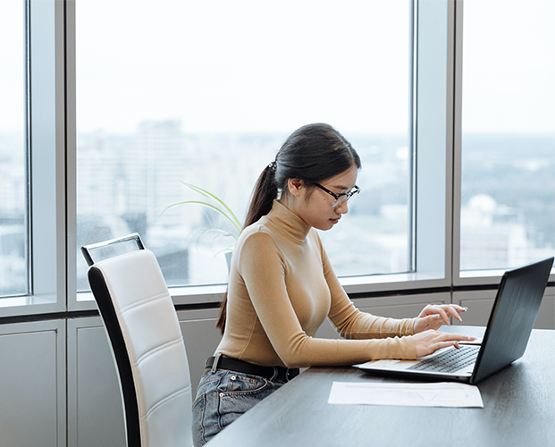 Side view of focused female remote worker surfing netbook