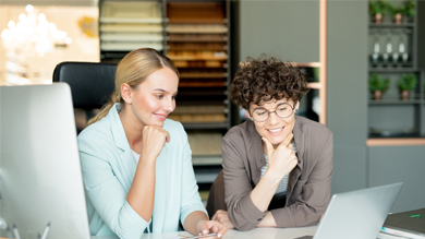 Two young women working together at laptop