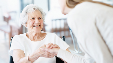 Happy patient is holding caregiver for a hand while spending time together