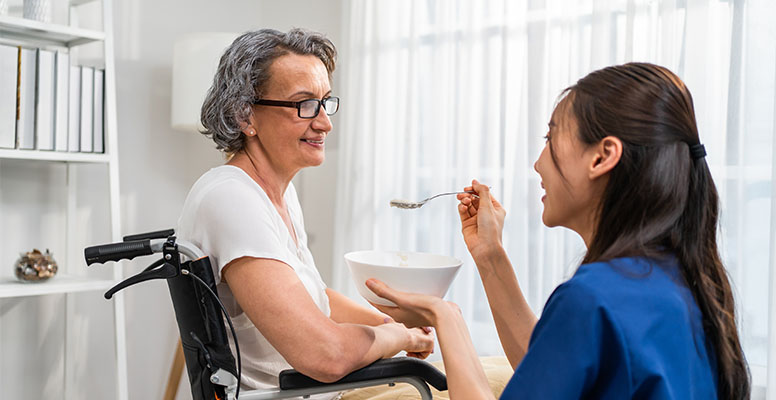 Asian caregiver nurse serve food