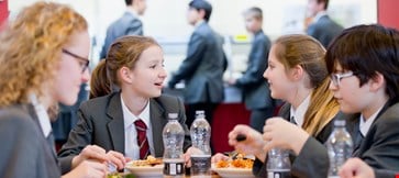 A group of middle school students eating lunch in the school cafeteria.