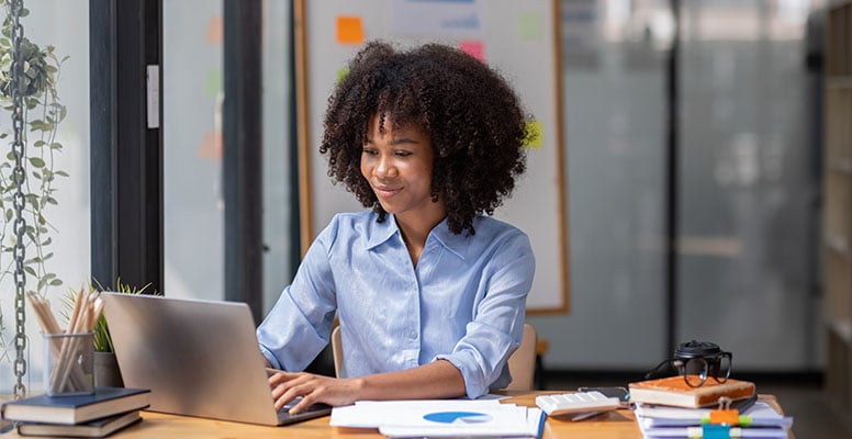 Happy woman working on laptop in Office