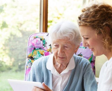 Young and old woman discussing on tablet computer