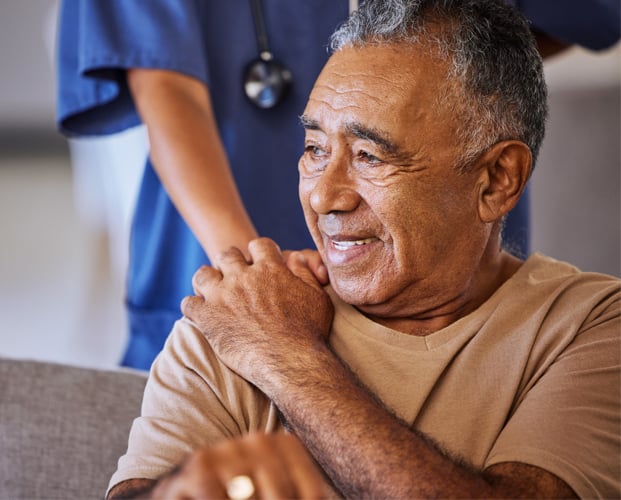 Caregiver holding hand of her sad senior patient