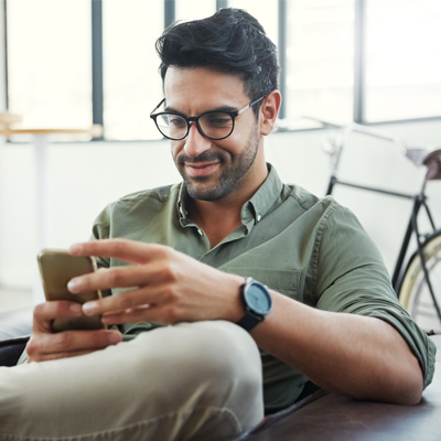 Shot of a design professional using his phone while sitting in an office