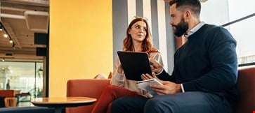 two-young-entrepreneurs-having-an-important-discussion-in-an-office-lobby